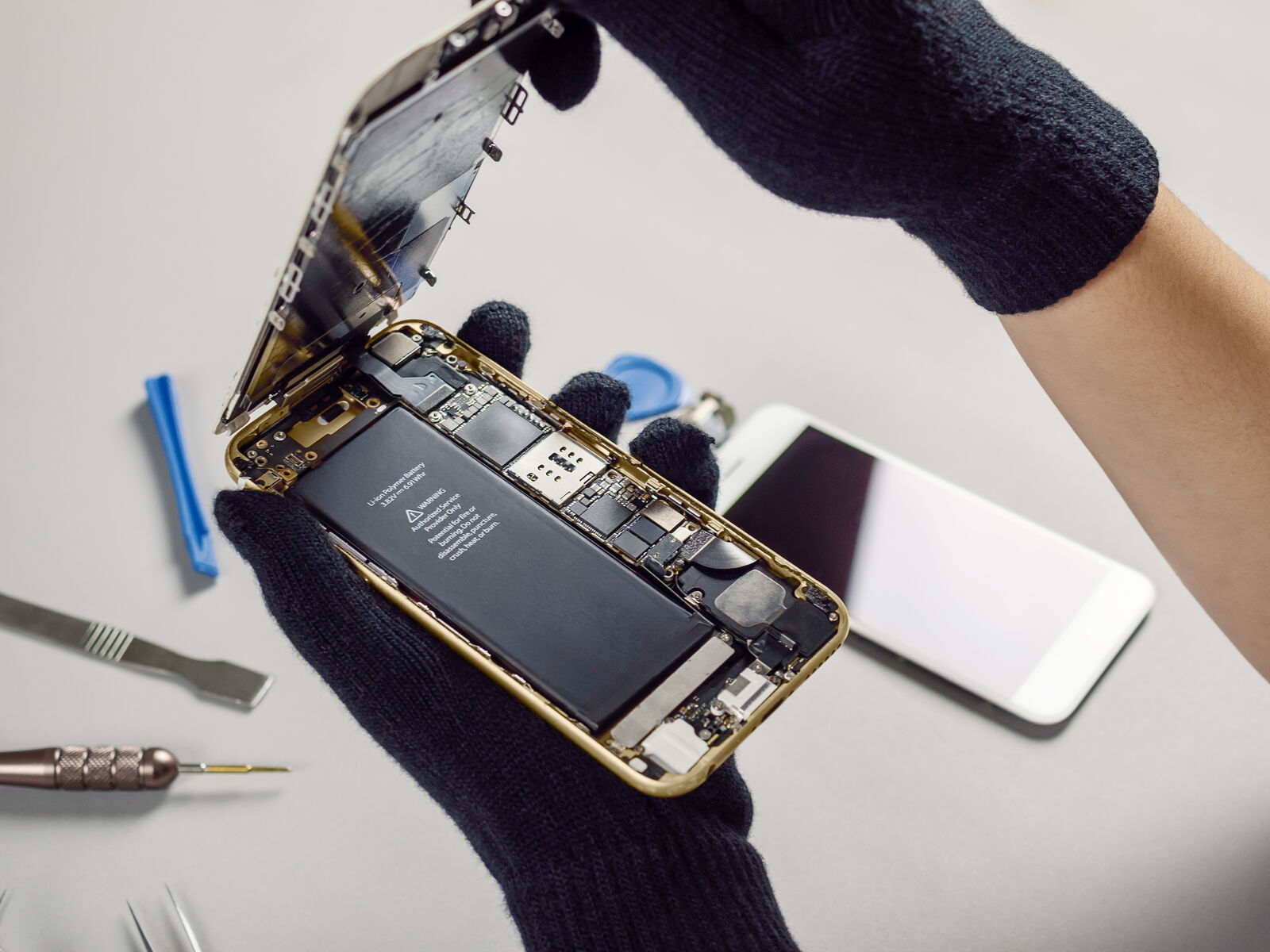 Technician opening an iPhone on the repair bench
